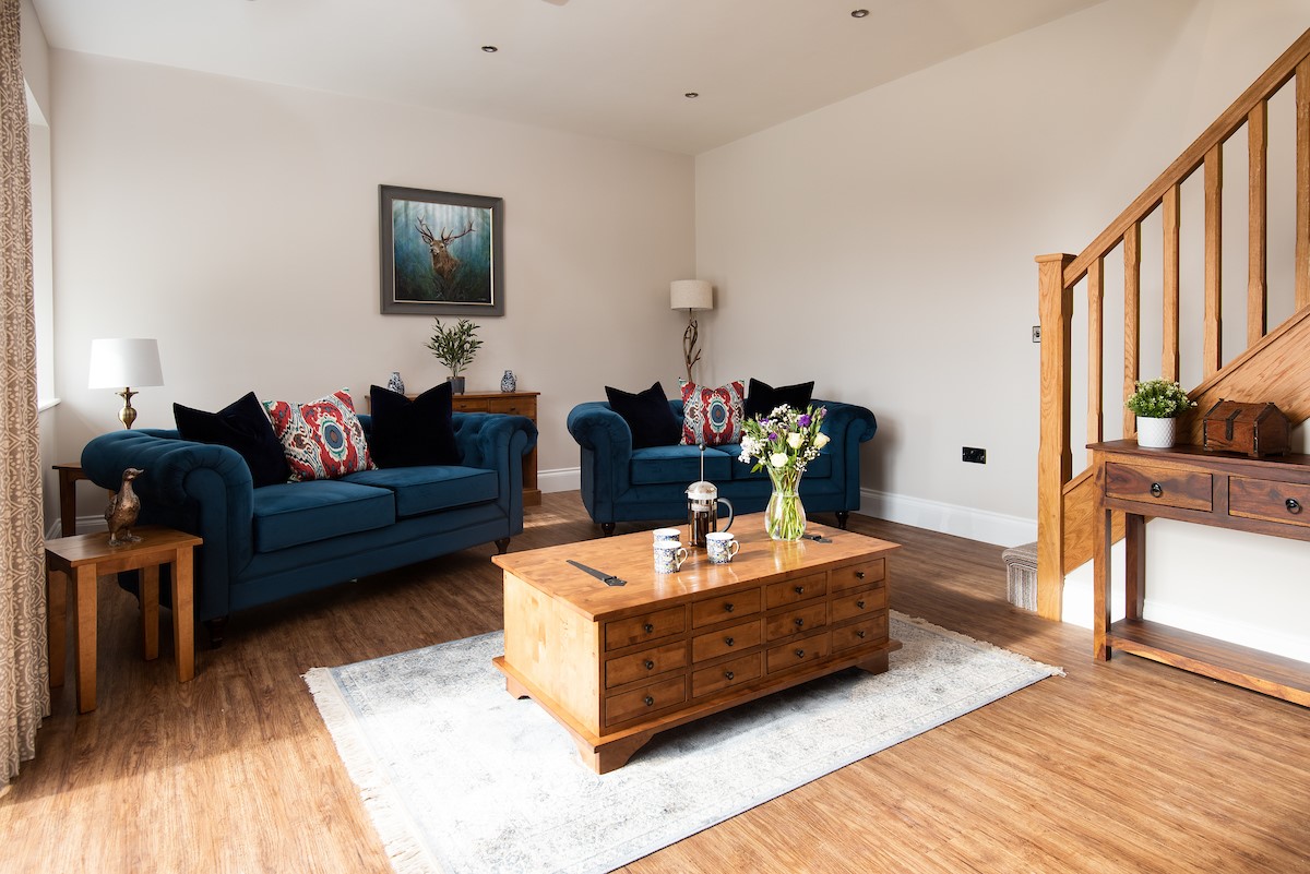 Mill Cottage, Brockmill Farm - two two-seater sofas in the sitting room with coffee table, Smart TV and log burner