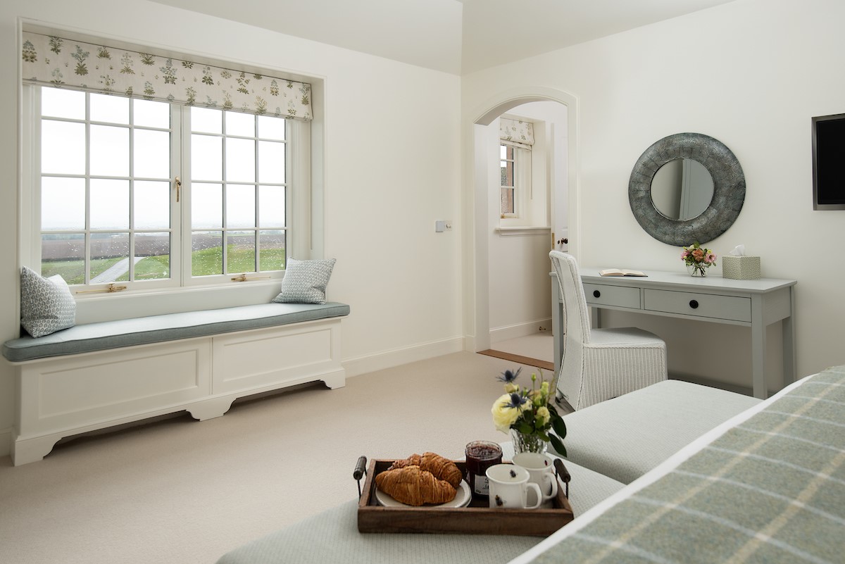 Hillside Cottage - bedroom two with window seat offering panoramic views and dressing table with mirror and chair