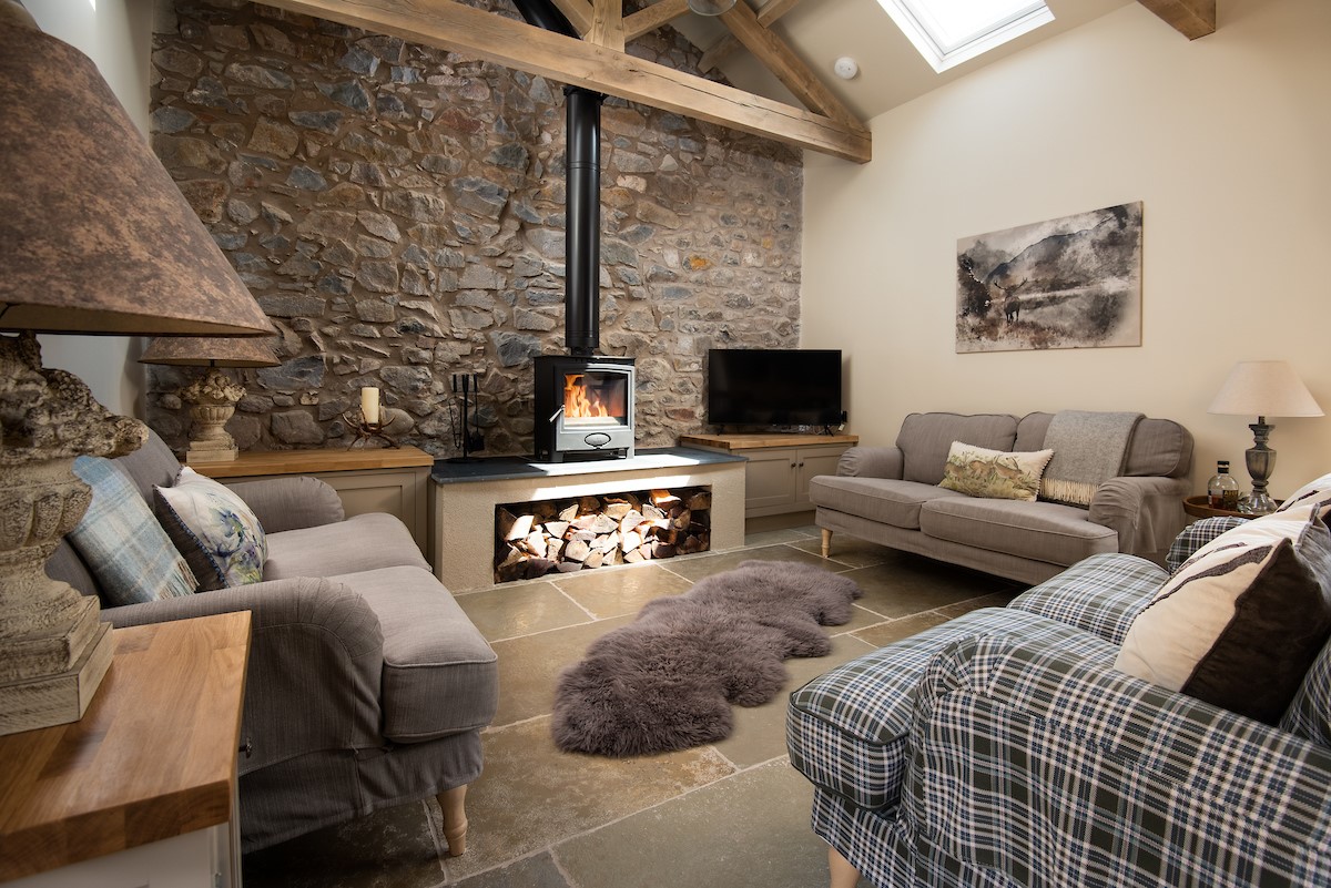 The Old Byre at West Moneylaws - the living area features flagstone floors and a woodburning stove