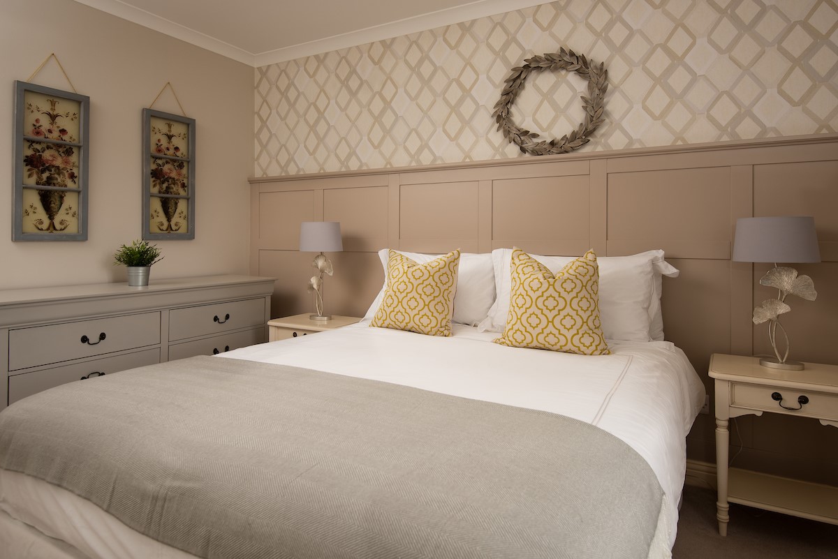 The Laurels - bedroom one with king size bed, chest of drawers and bedside tables