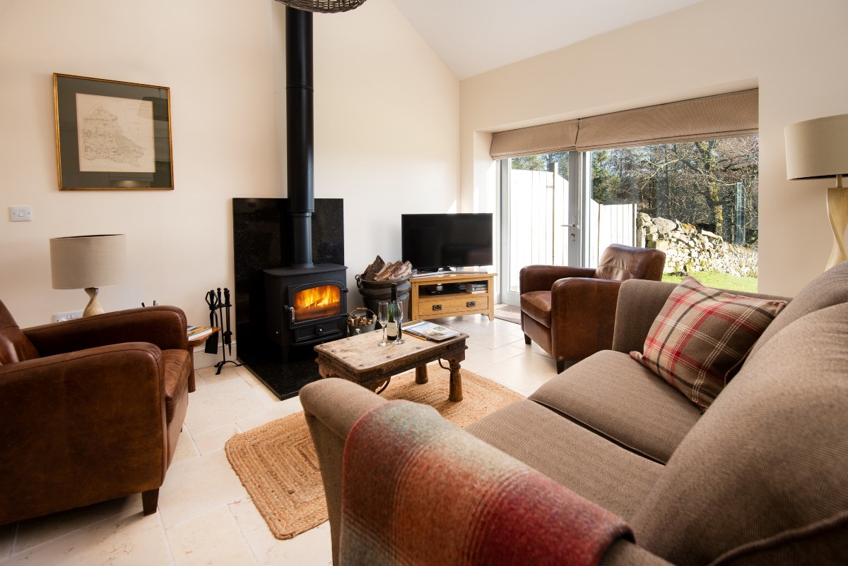 The Old Barn - relax in front of the wood burning stove whilst enjoying the views from the floor to ceiling feature window