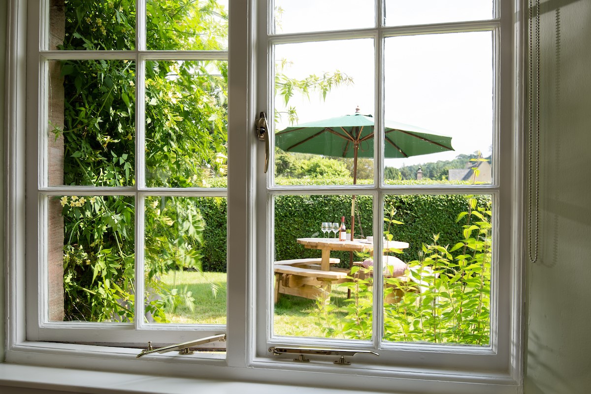 Laurel Cottage - kitchen window looking to the rear garden with outdoor dining space