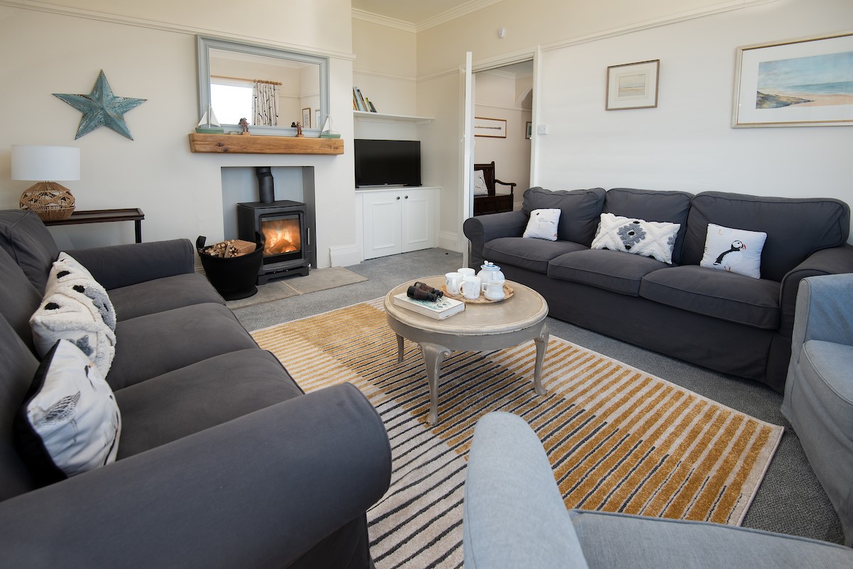 The Fairway - bright and cosy sitting room with comfortable sofas and armchairs