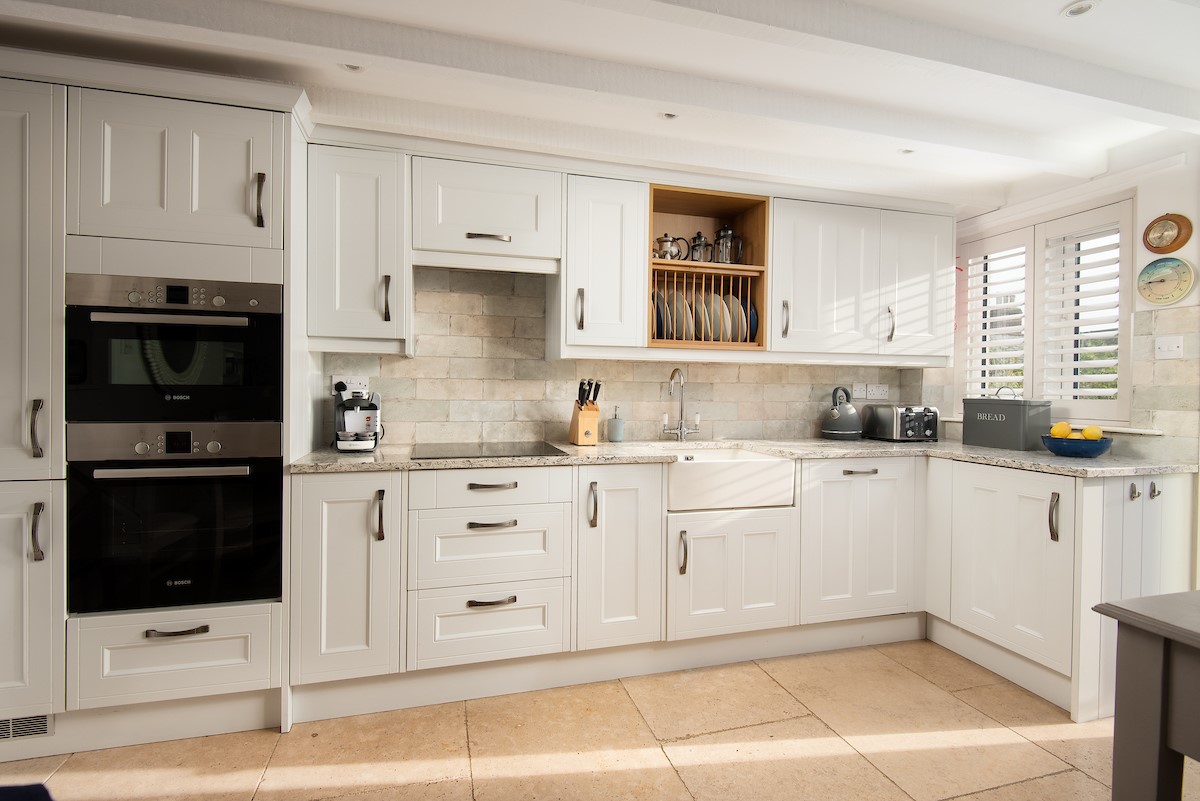 The Arch - shaker style kicthen containing integrated fan oven, combi microwave, induction hob, fridge freezer and dishwasher