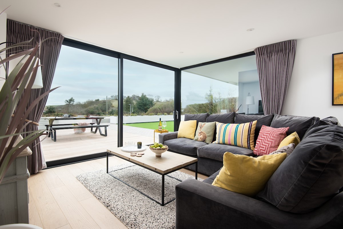 1 The Bay, Coldingham - full-length sliding doors and wrap-around window filling the sitting area with daylight