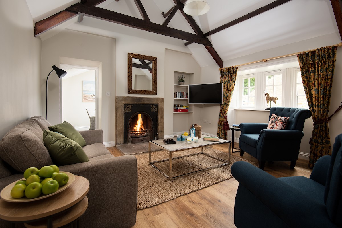East End Cottage - the spacious sitting room with beamed ceiling and an open fire