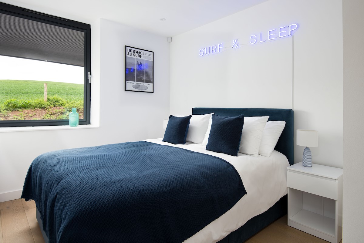 2 The Bay, Coldingham - bedroom one features a king size bed with bespoke neon sign mounted above