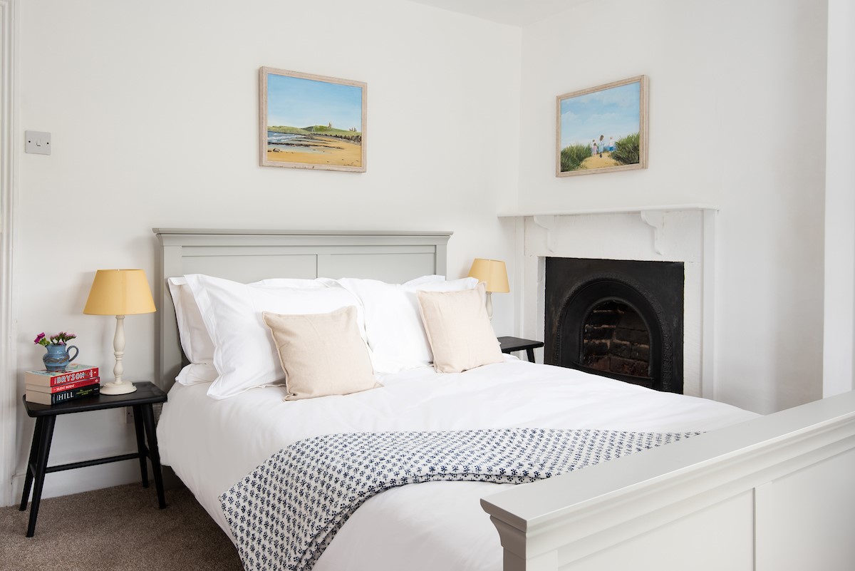 Appletree Cottage - bedroom one with double bed and a feature fireplace