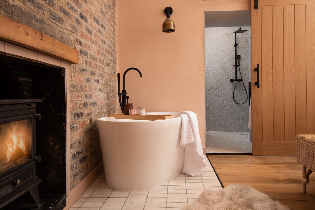 East Lodge Home Farm - free-standing bath in bedroom one with cosy log burner