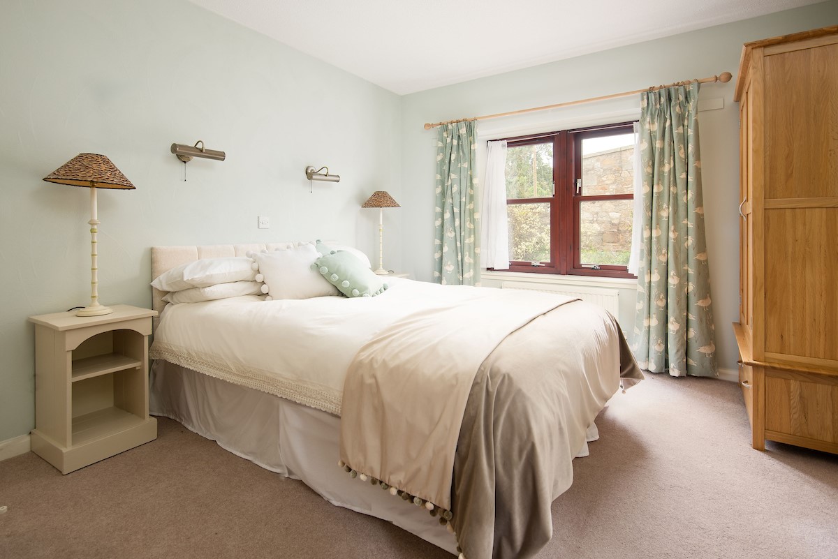 Westwood Cottage - bedroom one with king size bed and freestanding wooden wardrobe
