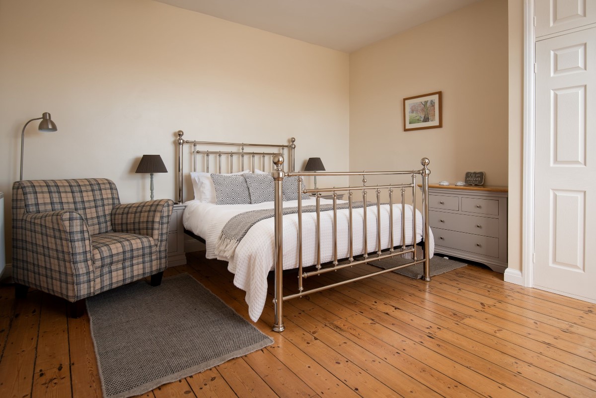 Chaffinch Cottage - bedroom one with king size bed, chest of drawers and armchair