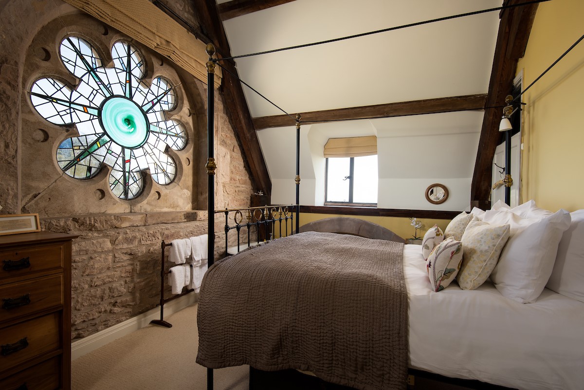 Lindisfarne View - bedroom one with cast iron king size bed and stained glass feature window