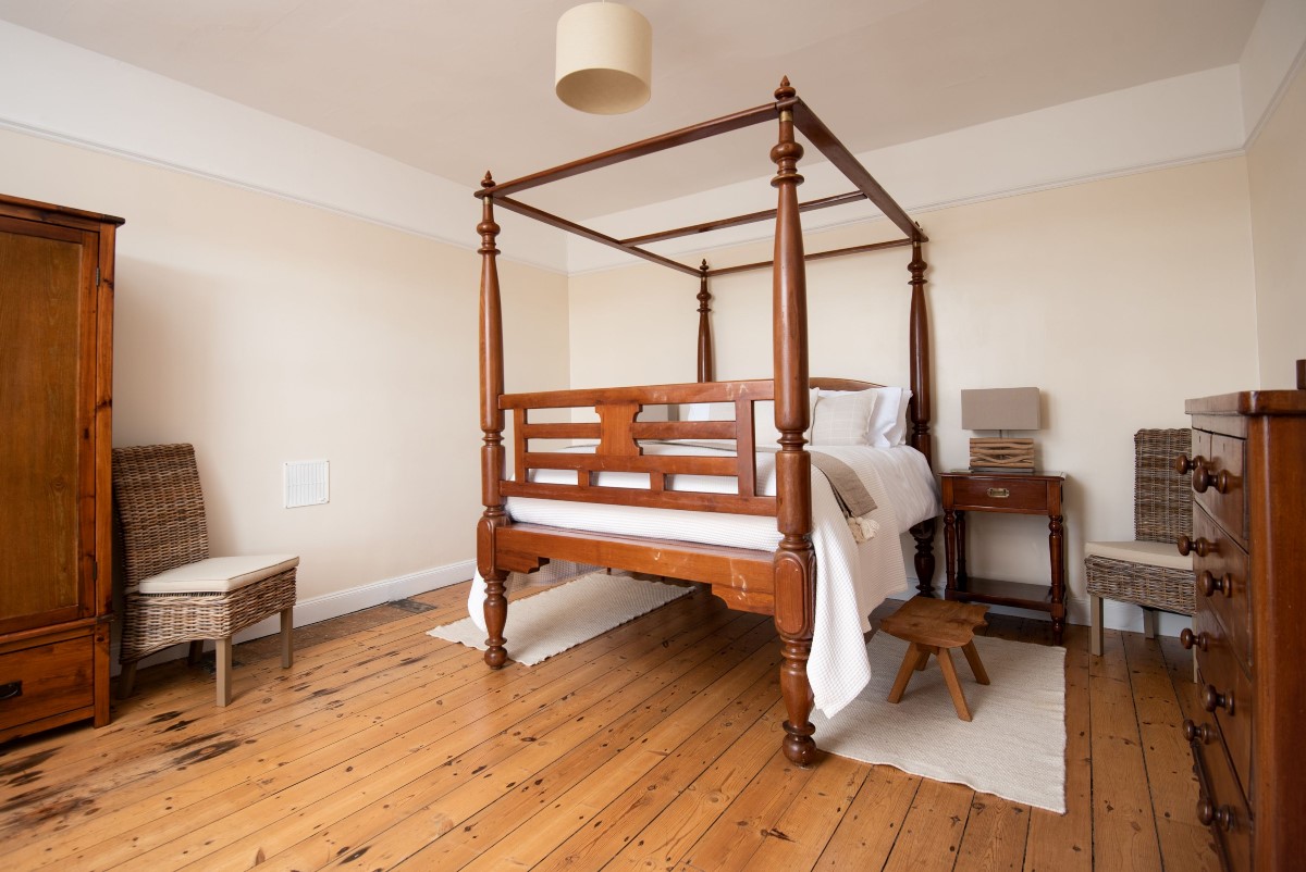 Dipper Cottage - bedroom one with king size, four-poster bed, chest of drawers and side tables