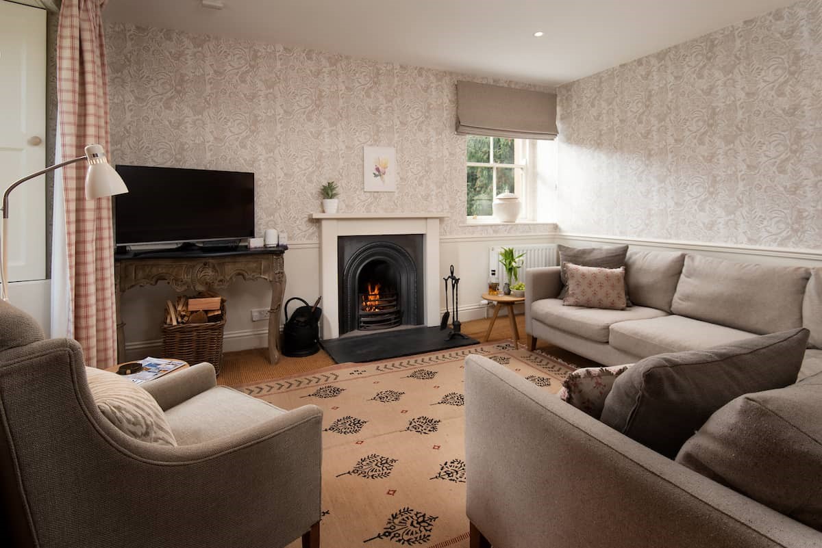 Garden House - sitting room with large corner sofa, open fire, dual aspect views and TV