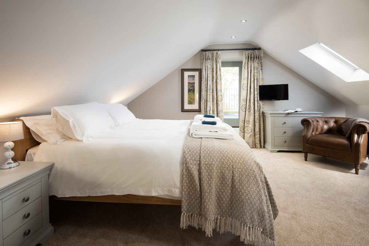 The Granary at Rothley East Shield - bedroom one with king size bed and door leading to north-facing fenced roof terrace