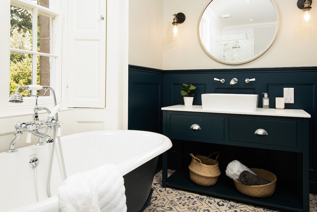 Cairnbank House - bedroom one en suite with vanity unit and roll top bath