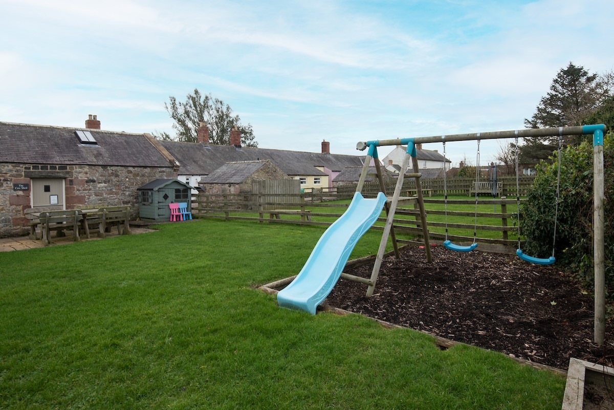 Moo House - play area with swings and slide to keep children entertained in the garden