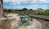 Farm Cottage - pretty front garden with furniture and road leading to Cheswick beach