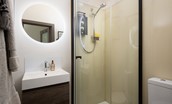 The Upper Deck - shower room with corner shower, basin with illuminated mirror, and WC
