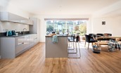 East Bay Beach House - modern kitchen with island, dining table and views of the garden