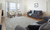 East Bay Beach House - sitting room with plenty of seating, large bay window and sea views