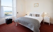 East Bay Beach House - bedroom one with double bed, side table and sea views