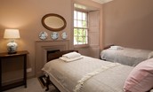 Cloister House - bedroom four with twin beds and decorative fireplace