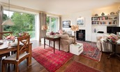 Brunton Burn - the spacious open-plan sitting room with wood burning stove, views of the burn and dining space for four guests