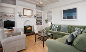 The Tumblers - large corner sofa and armchair in the sitting room with wood burner and TV