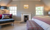Blackhouse Forest Estate - bedroom three with soft occasional chair and decorative log burner