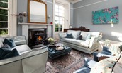 Cairnbank House - the bright drawing room with sumptuous sofas set around the wood burning stove