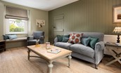 Campsie Cottage - the sitting room flaunts a gentle colour scheme and lovely combination of soft linen furnishings and full height beadboarding on one wall