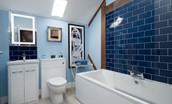 Walltown Farm Cottage - second floor family bathroom with shower over bath, WC, and basin with illuminated mirror above