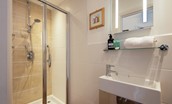 Nook End - en-suite shower room with shower, WC, and basin with illuminated mirror above