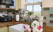 April Cottage - the kitchen has a Belfast sink and views of the coast