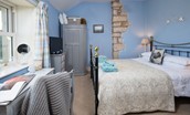 April Cottage - bedroom one with king size bed, exposed stone and coastal views