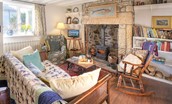 Artist's Cottage - the sitting room with wood burning stove, rocking chair and lots of characterful touches