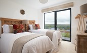 The Maple - bedroom two configured as twin beds with views of the Coquet valley from the patio doors