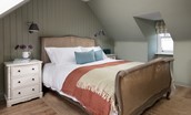 Campsie Cottage - the dual-aspect master bedroom is on the first floor, with a French-inspired bed set beneath sloping eaves