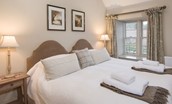Barley Hill Cottage - bedroom one with zip and link beds and muted furnishings