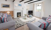 Beachcomber Cottage - sitting room with coastal themed furnishings and artwork