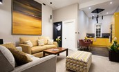 The Scott Apartment - the apartment's open-plan living space has a spacious seating area and sleek yellow kitchen