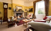 The Old Manse - drawing room with large open fire, grandfather clock and collection of antique pieces