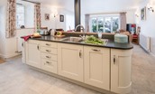 Boundary Bank - the kitchen island with sink backing onto the wood burning stove