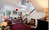 Brunton House - large hall with staircase, seating area, wood-burning stove and piano