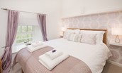 Budle Bay Loft - bedroom one with king size bed and lilac tones