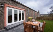 Byre - garden with outside seating area and bi-folding doors into the sitting room