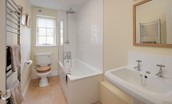 Coachman's Cottage - bedroom one en suite bathroom with bath and shower over, WC and basin