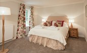 Daffodil Cottage - bedroom one with king size bed, side tables and floral furnishings