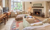 East Cottage - sitting room with sofas, open fire and TV